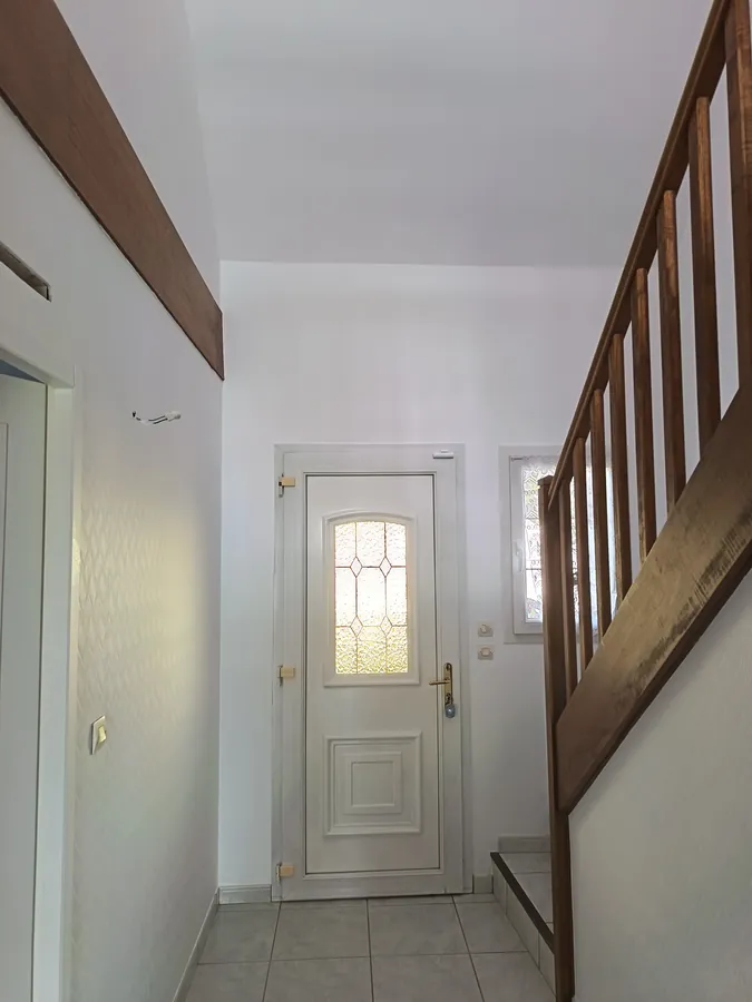 Couloir après travaux — entrée entièrement repeinte en blanc dans le Loiret