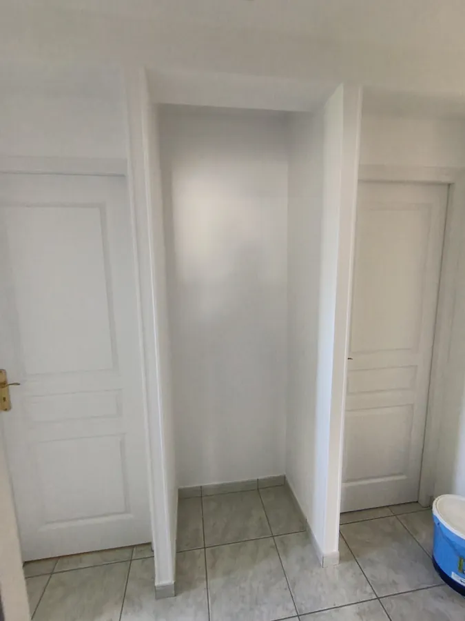 Palier haut après travaux — couloir blanc et lumineux