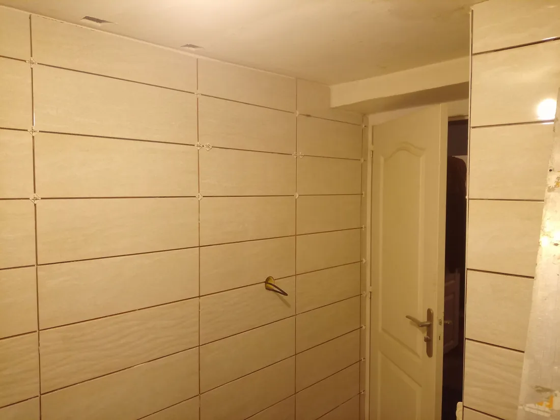 Salle de bain en travaux à Ormes — mur avec radiateur, faïence posée